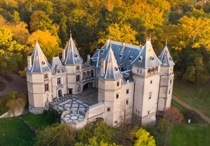 Malowniczy zamek w Polsce otoczony jesiennym lasem. Wspaniała architektura z wieżyczkami i dziedzińcem.