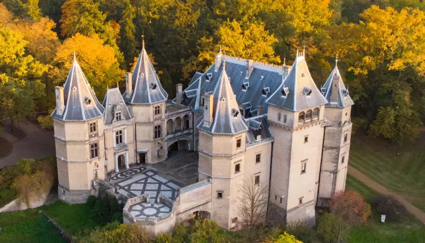 Malowniczy zamek w Polsce otoczony jesiennym lasem. Wspaniała architektura z wieżyczkami i dziedzińcem.