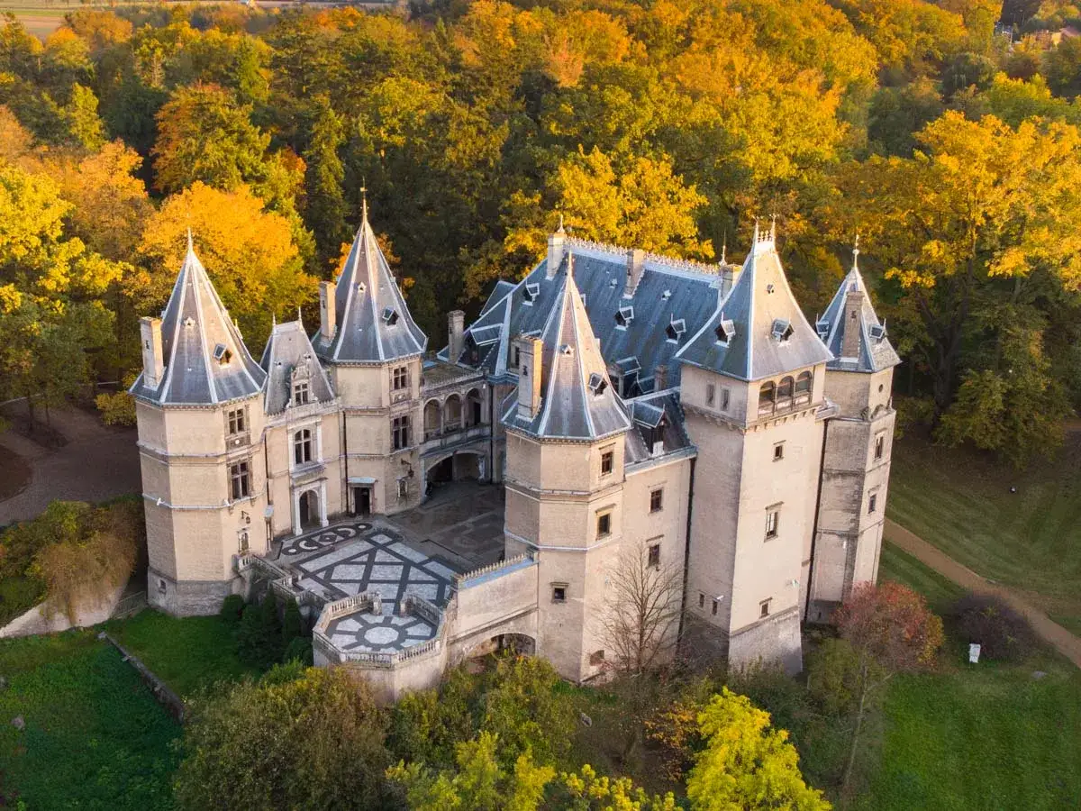 Malowniczy zamek w Polsce otoczony jesiennym lasem. Wspaniała architektura z wieżyczkami i dziedzińcem.