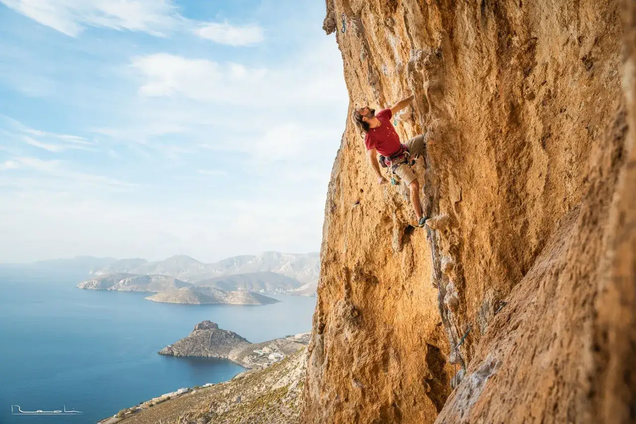 Wspinacz na skale na Kalymnos, z widokiem na morze i wyspy. Niesamowite kalymnos wspinanie w słońcu.