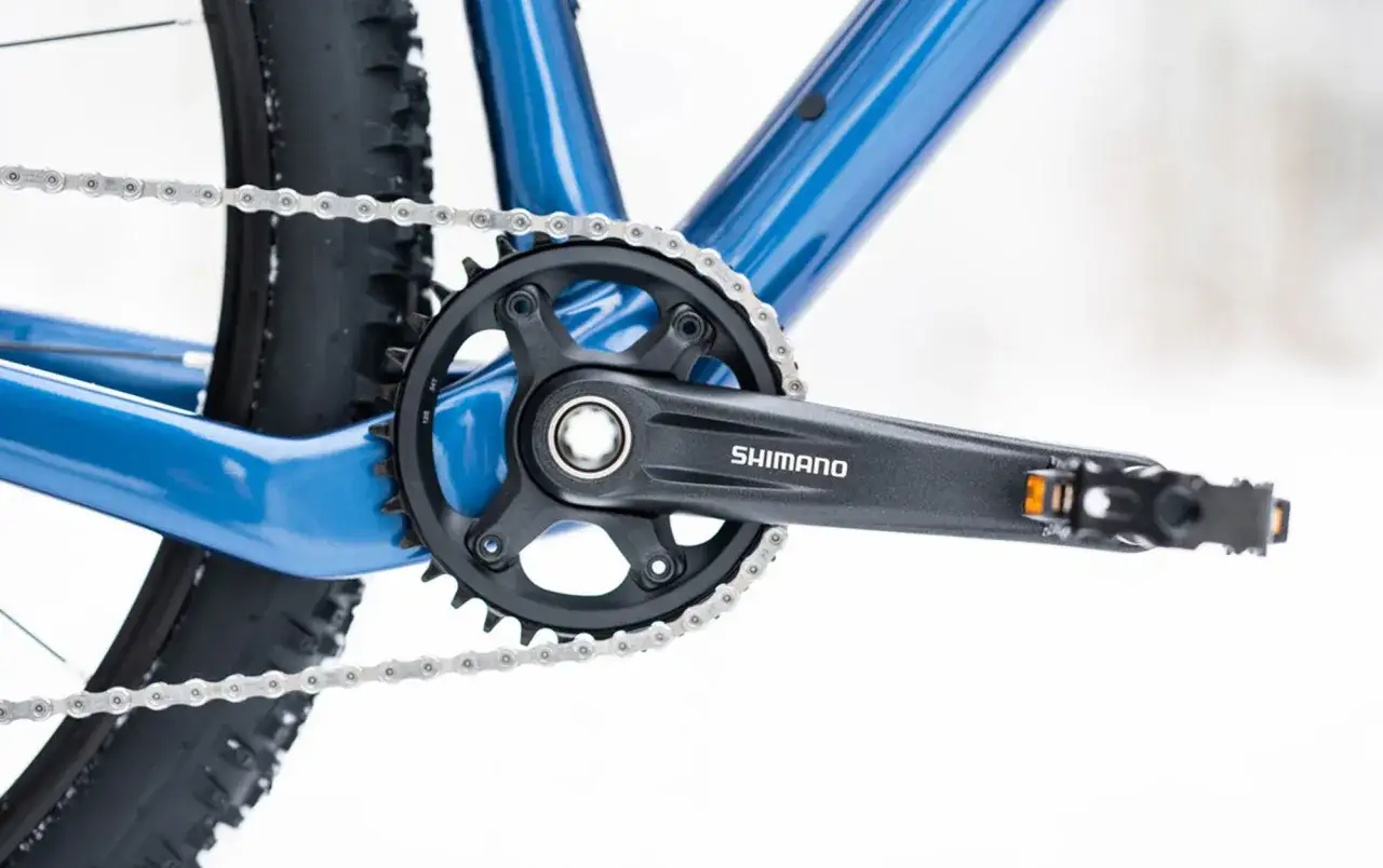 Jak odkręcić pedały w rowerze? Widok na korbę Shimano, łańcuch i fragment ramy.