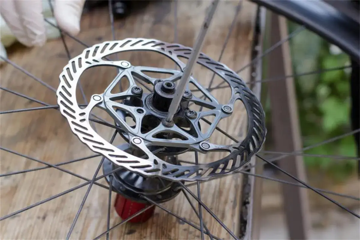 Naprawiam rowerowy hamulec tarczowy. Widoczny jest mechanizm center lock, do którego przykręcona jest tarcza.